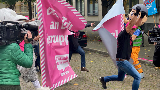 Läufer laufen durch das zerrissene BAnner.