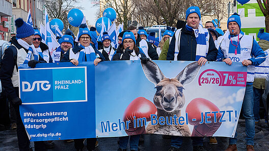 Demonstranten halten ein Kampagnentransperent an der Spitze eienr großen Demonstrantengruppe auf einer Straße
