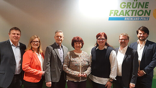 Gruppenbild mit sechs Personen vor einer Wand mit Logo von BÜNDNIS 90/DIE GRÜNEN
