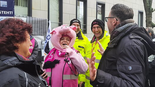 Vier Personen im Gespräch vor einem Gebäude.