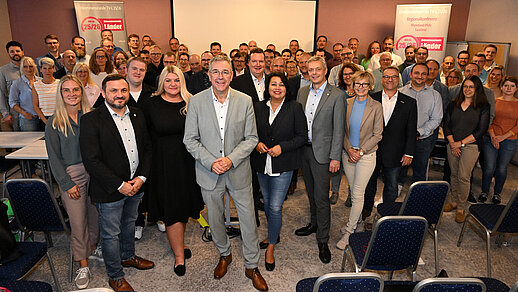Gruppenbild mit rund 70 Personen in einem Tagungsraum.