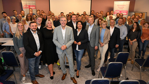 Gruppenbild mit rund 70 Personen in einem Tagungsraum.