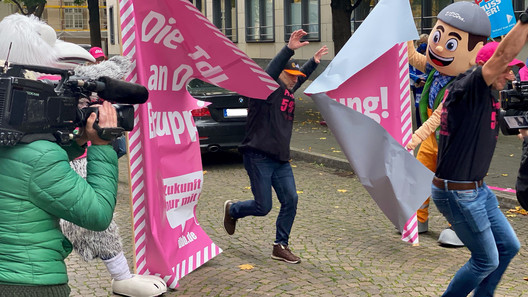 Läufer mit erhobenen Armen vor Banner.