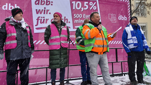 Redner auf einem Podium vor Kampagnen-Banner