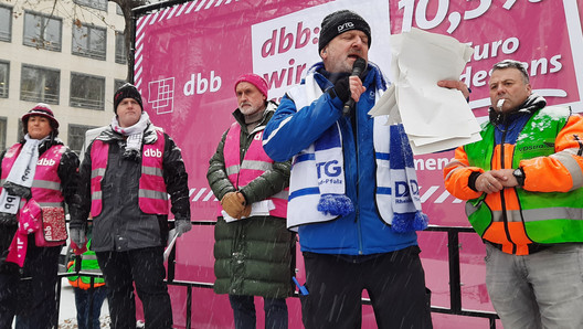 Redner auf einem Podium vor Kampagnenbanner