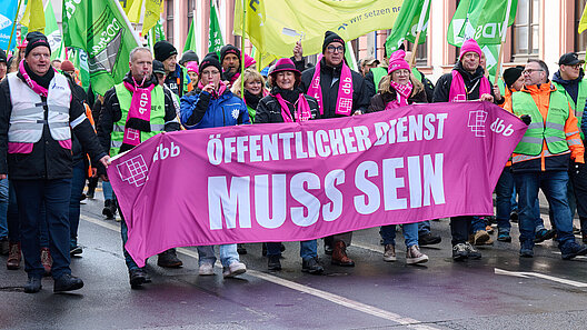 Demonstranten tragen ein Transparent an der Spitze eines Demonstrationszuges